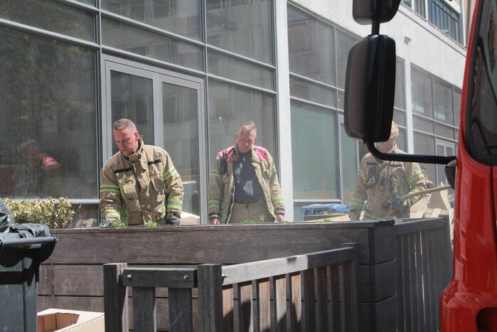 Schade aan vlonder na brand in stapel karton