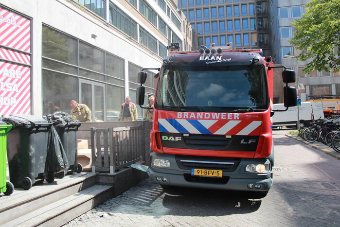 Schade aan vlonder na brand in stapel karton