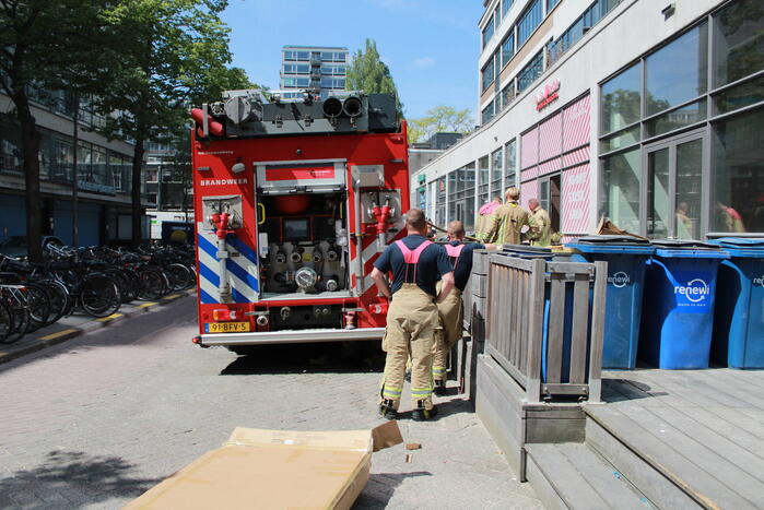 Schade aan vlonder na brand in stapel karton