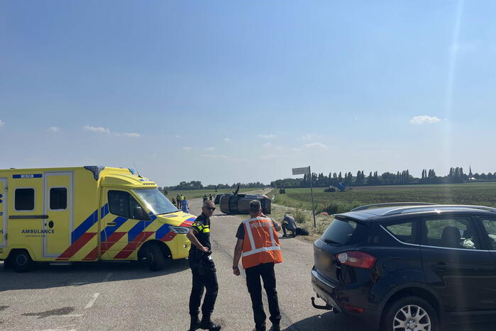 Auto op zijn kant bij botsing