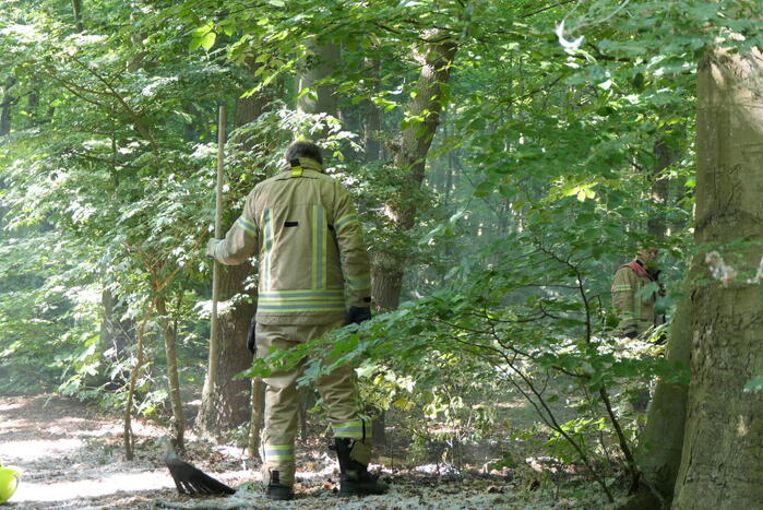 Brandweer blust smeulende delen in duingebied