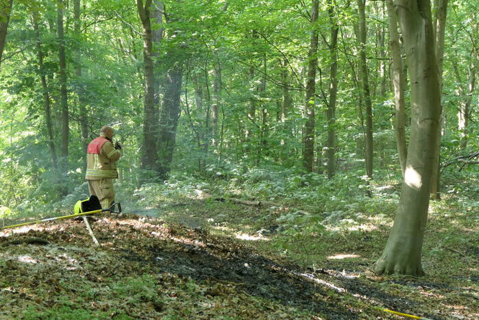 Brandweer blust smeulende delen in duingebied