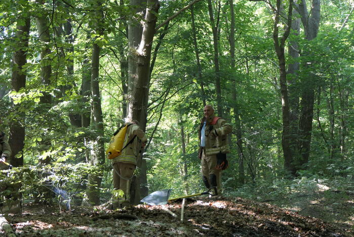 Brandweer blust smeulende delen in duingebied