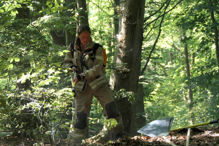 Brandweer blust smeulende delen in duingebied