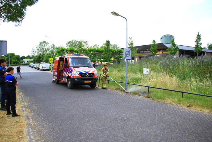 Berm in brand bij winkelcentrum
