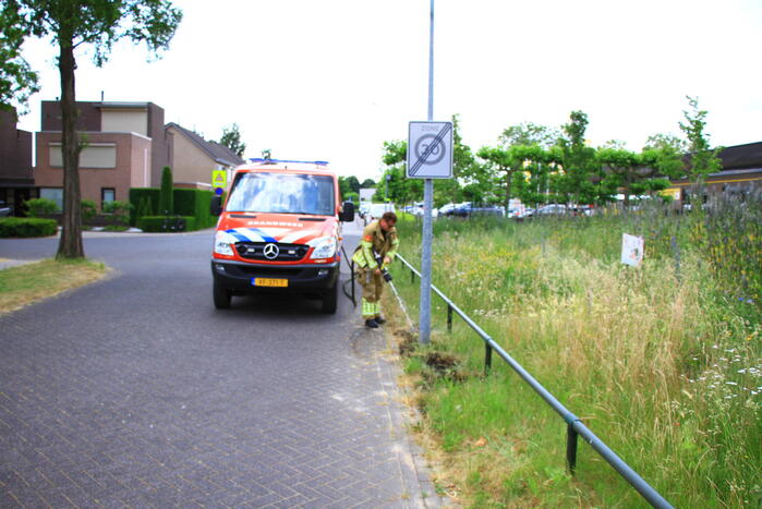 Berm in brand bij winkelcentrum