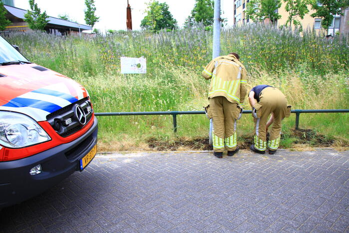Berm in brand bij winkelcentrum