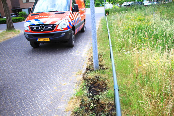 Berm in brand bij winkelcentrum