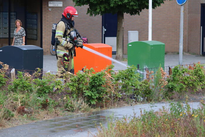 Gedumpt afval bij containers in brand