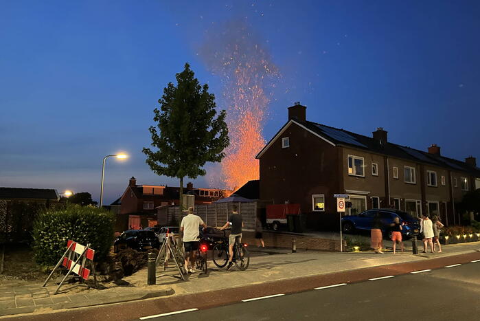 Felle brand in struiken van achtertuin