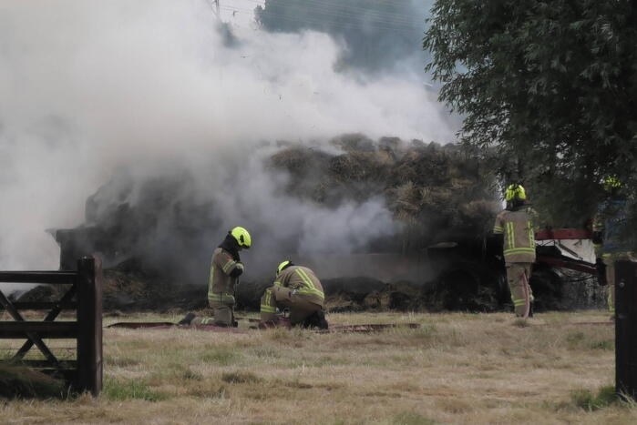 Trailer geladen met hooibalen uitgebrand in weiland