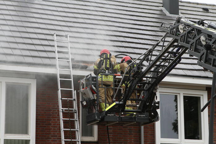 Brandweer sloopt dak bij brand