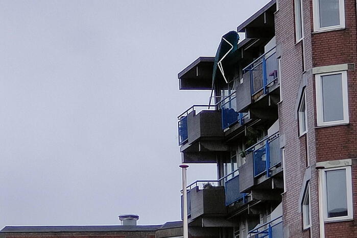 Brandweer verwijderd losgewaaid zonnescherm