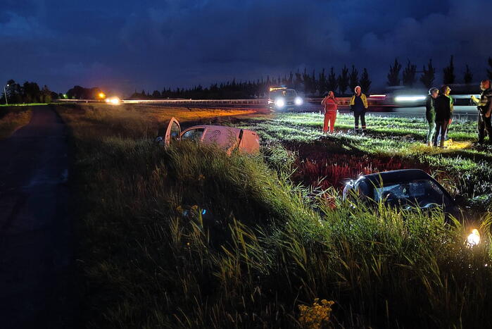 Busje en auto belanden in sloot