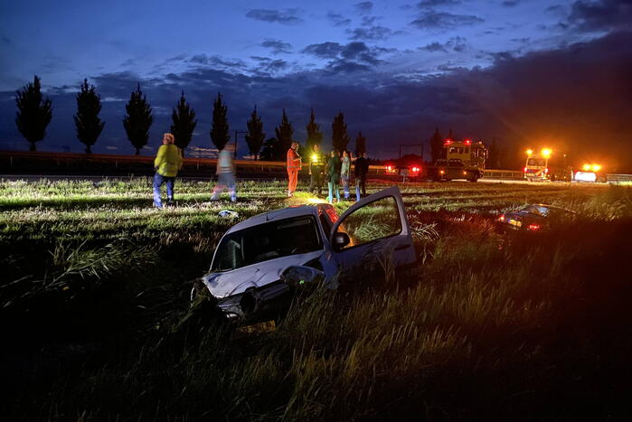 Busje en auto belanden in sloot