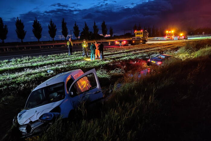 Busje en auto belanden in sloot