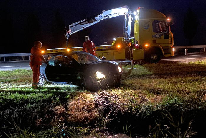 Busje en auto belanden in sloot