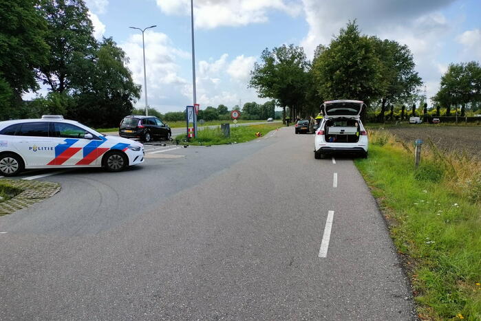 Twee personenauto's botsen op kruising