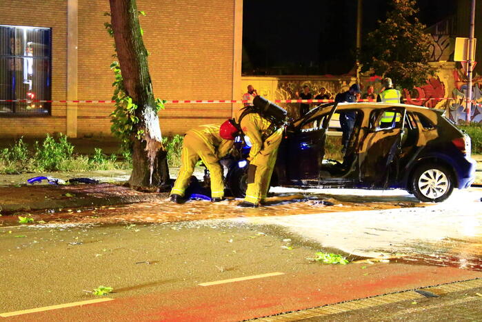 Auto in brand na frontale botsing tegen boom, twee gewonden