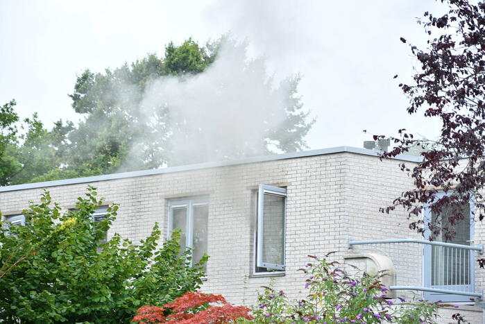 Zwarte rook uit woning door brand