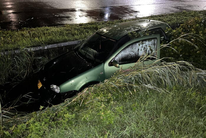 Auto glijdt de bocht uit in een sloot