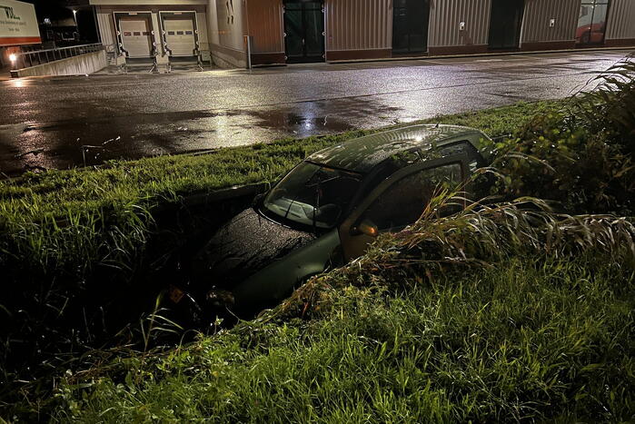 Auto glijdt de bocht uit in een sloot