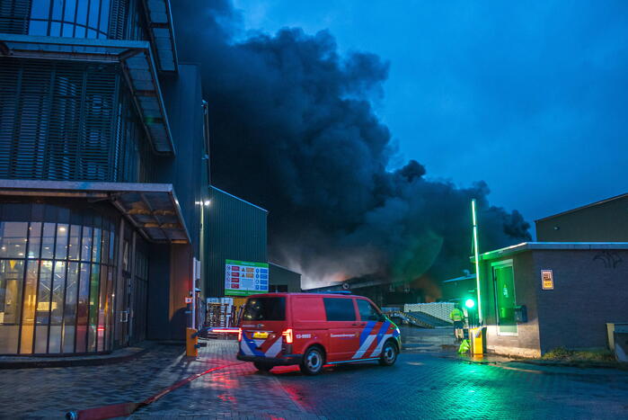 Zwarte rookpluimen boven havengebied door grote brand