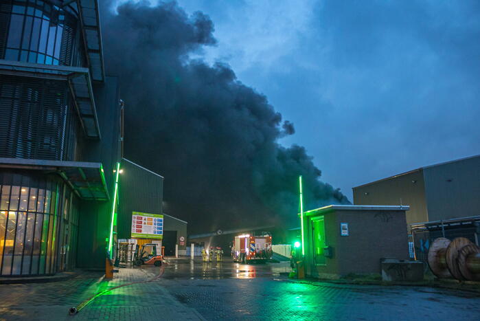 Zwarte rookpluimen boven havengebied door grote brand