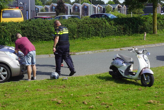 Automobilist en scooterrijder in botsing