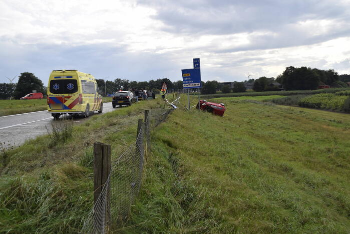 Automobilist belandt op zijkant naast afrit
