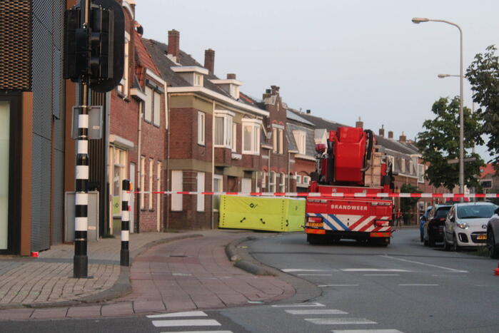 Man klimt op woning en gooit dakpannen naar hulpdiensten