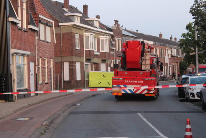 Man klimt op woning en gooit dakpannen naar hulpdiensten