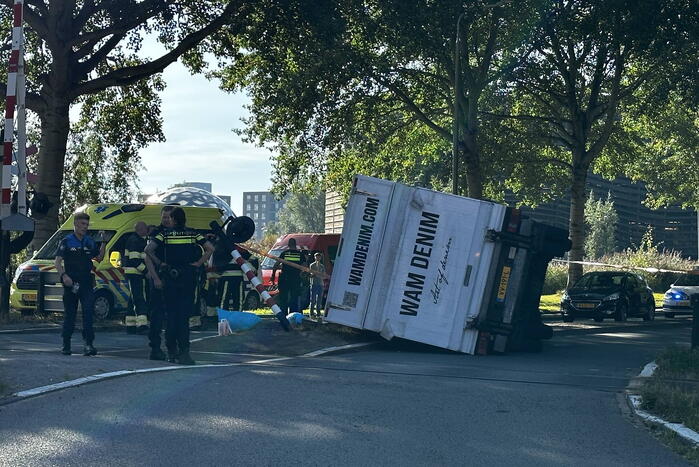 Vrachtwagen kantelt in bocht op overweg