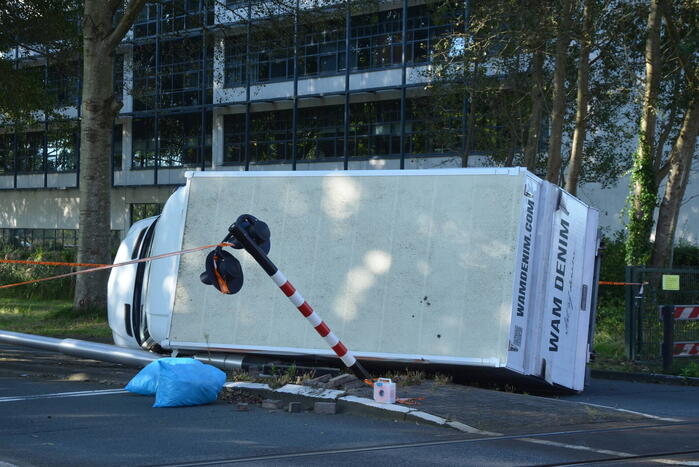 Vrachtwagen kantelt in bocht op overweg