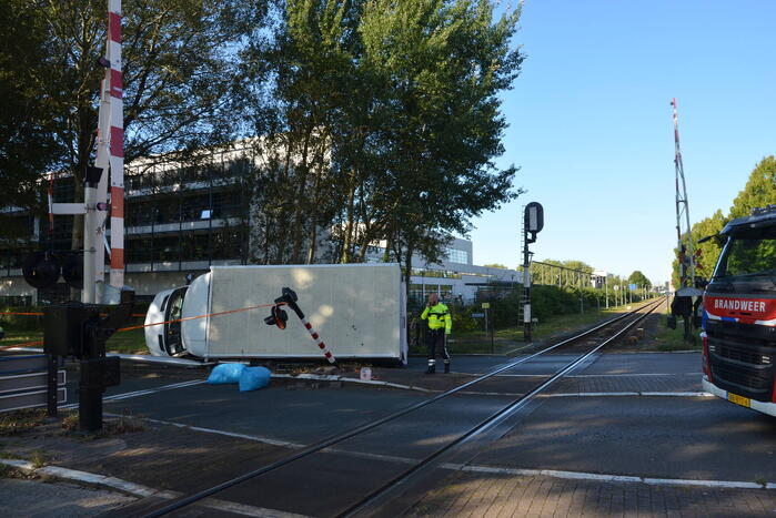Vrachtwagen kantelt in bocht op overweg