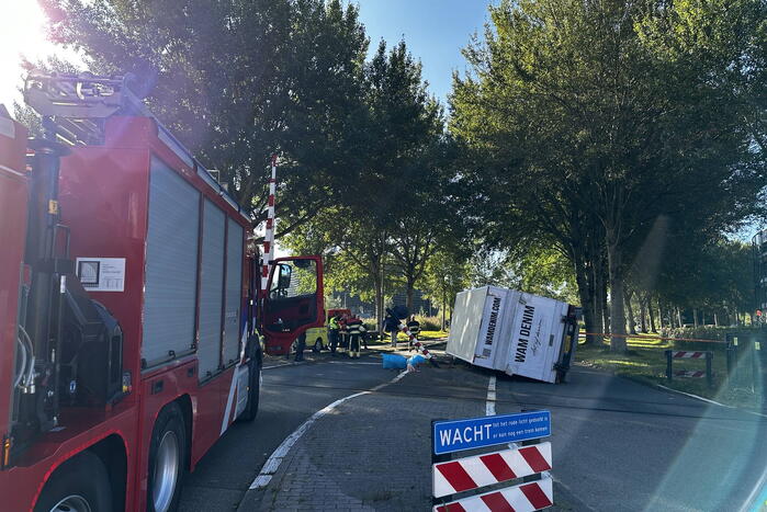 Vrachtwagen kantelt in bocht op overweg