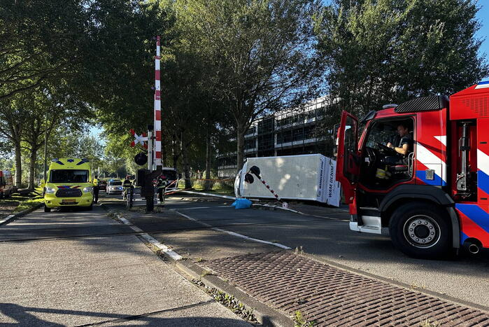 Vrachtwagen kantelt in bocht op overweg