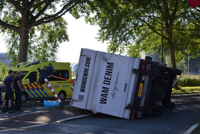 Vrachtwagen kantelt in bocht op overweg