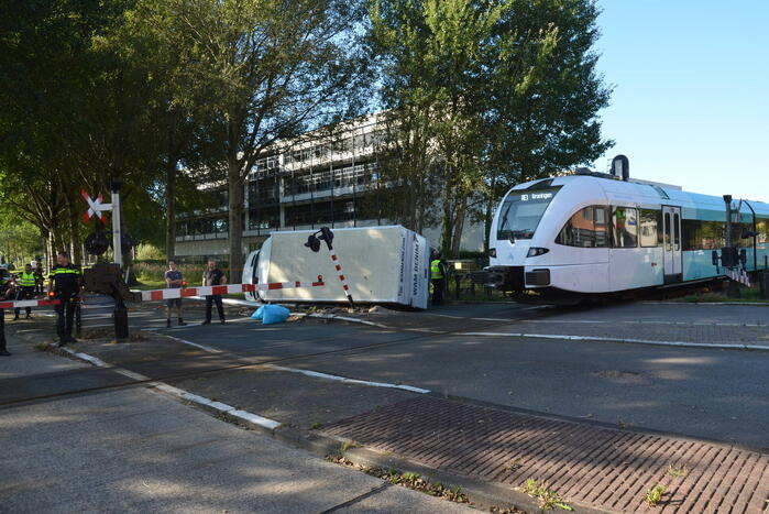 Vrachtwagen kantelt in bocht op overweg