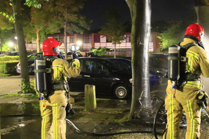 Scooter in brand tegen woning