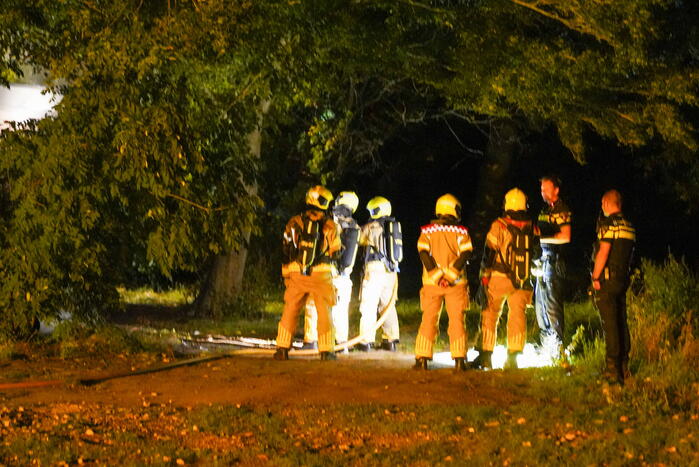 Bankstel tegen elektriciteitshuis in brand