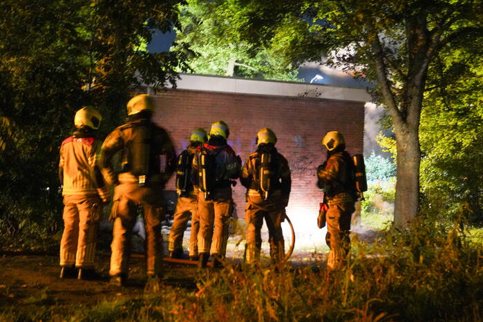 Bankstel tegen elektriciteitshuis in brand