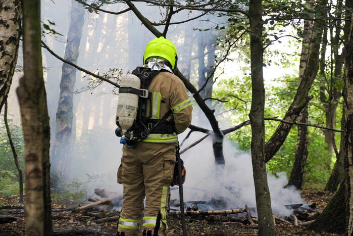 Brandweer blust kampvuur in bos