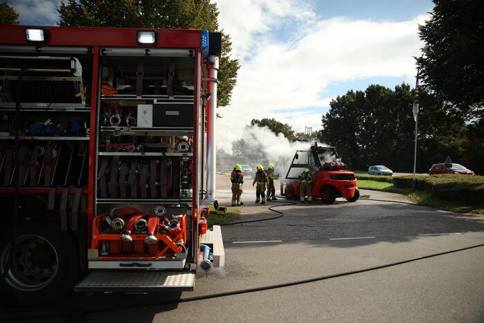 Brandweer blust brandende heftruck