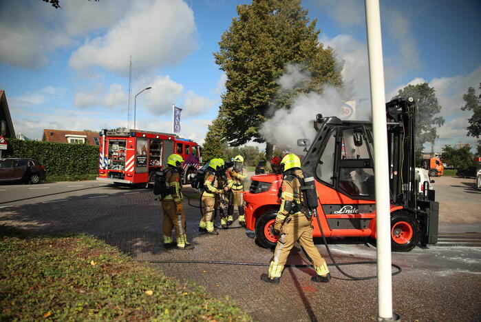 Brandweer blust brandende heftruck