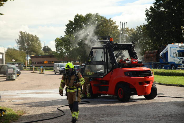 Brandweer blust brandende heftruck