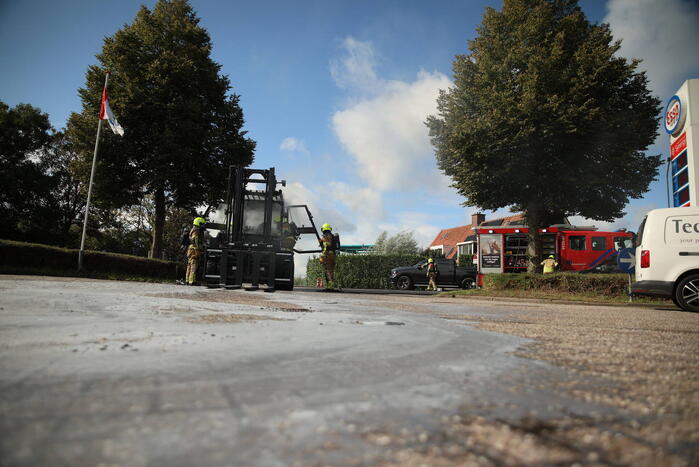 Brandweer blust brandende heftruck