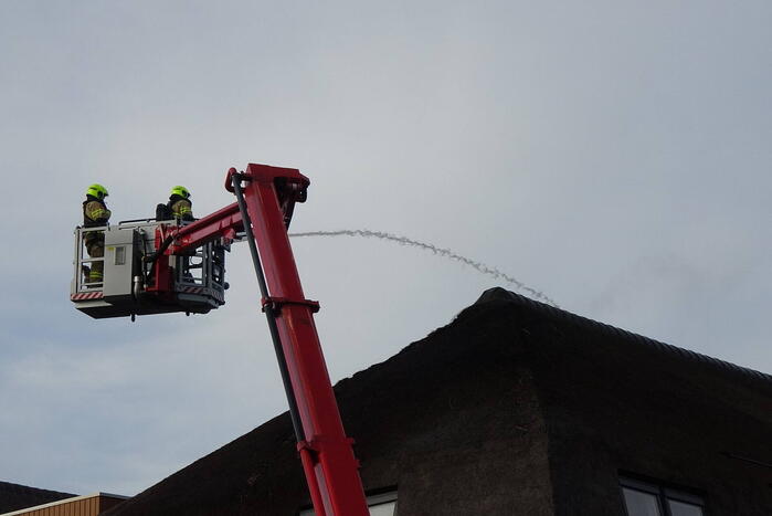 Brand op dak van appartementencomplex met rietendak