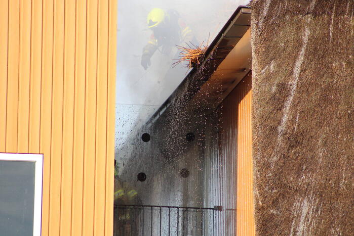 Brand op dak van appartementencomplex met rietendak