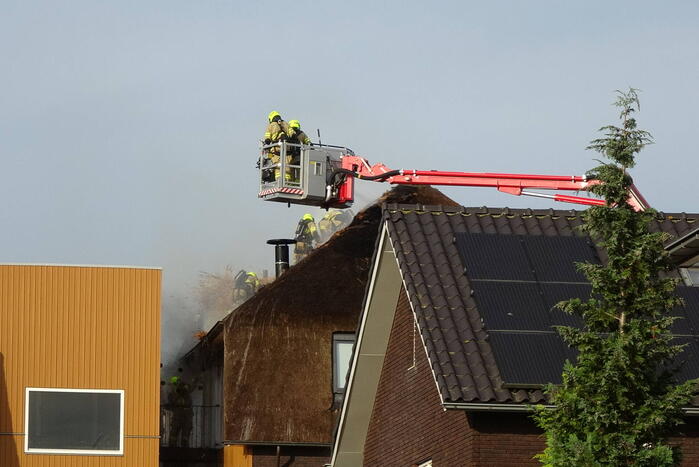 Brand op dak van appartementencomplex met rietendak